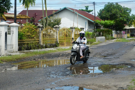 MELEWATI JALAN RUSAK