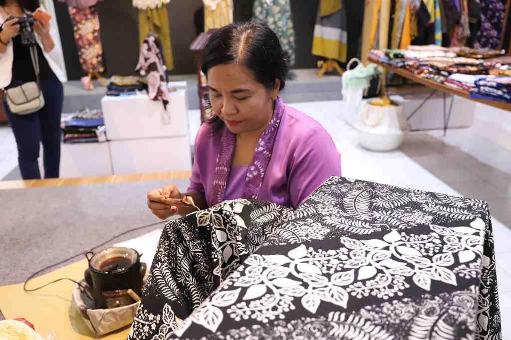 MENUNJUKKAN CARA MEWARNAI BATIK