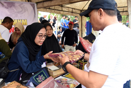 MELAYANI PENGUNJUNG PAMERAN UMKM