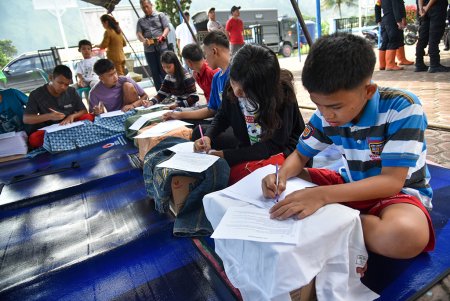 SISWA UJIAN AKHIR SEMESTER DI TENDA DARURAT