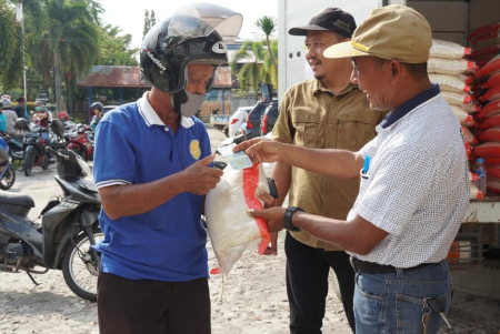 MENYERAHKAN BERAS MURAH 