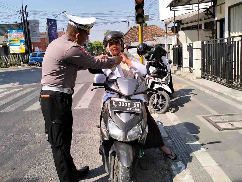 BANTU PASANG TALI PENGAMAN HELM